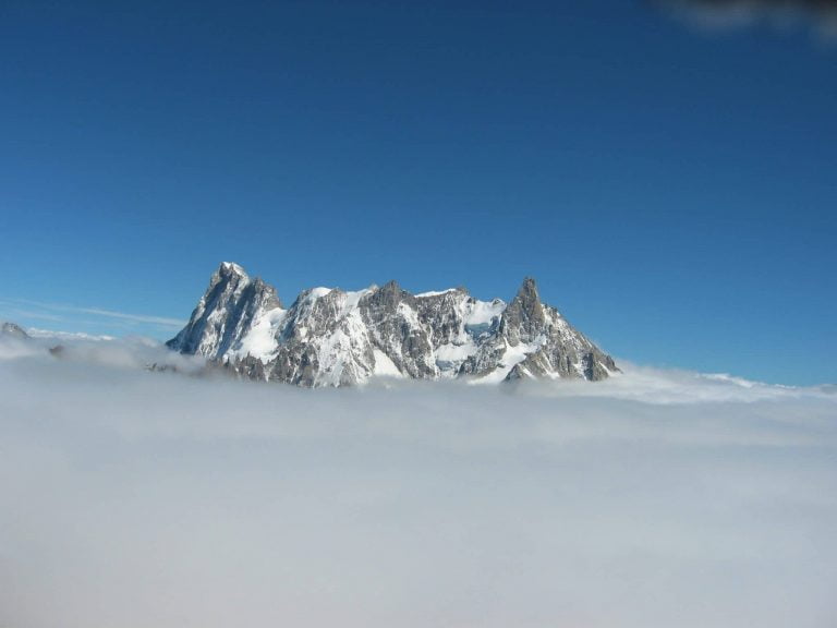 The Art of Route Setting 3 Snow-capped mountain peaks rising above the clouds