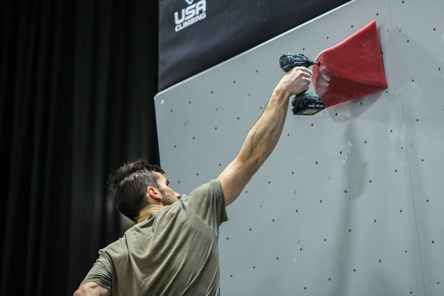 The Art of Route Setting 1 Route setter drilling a hold into a competition bouldering wall