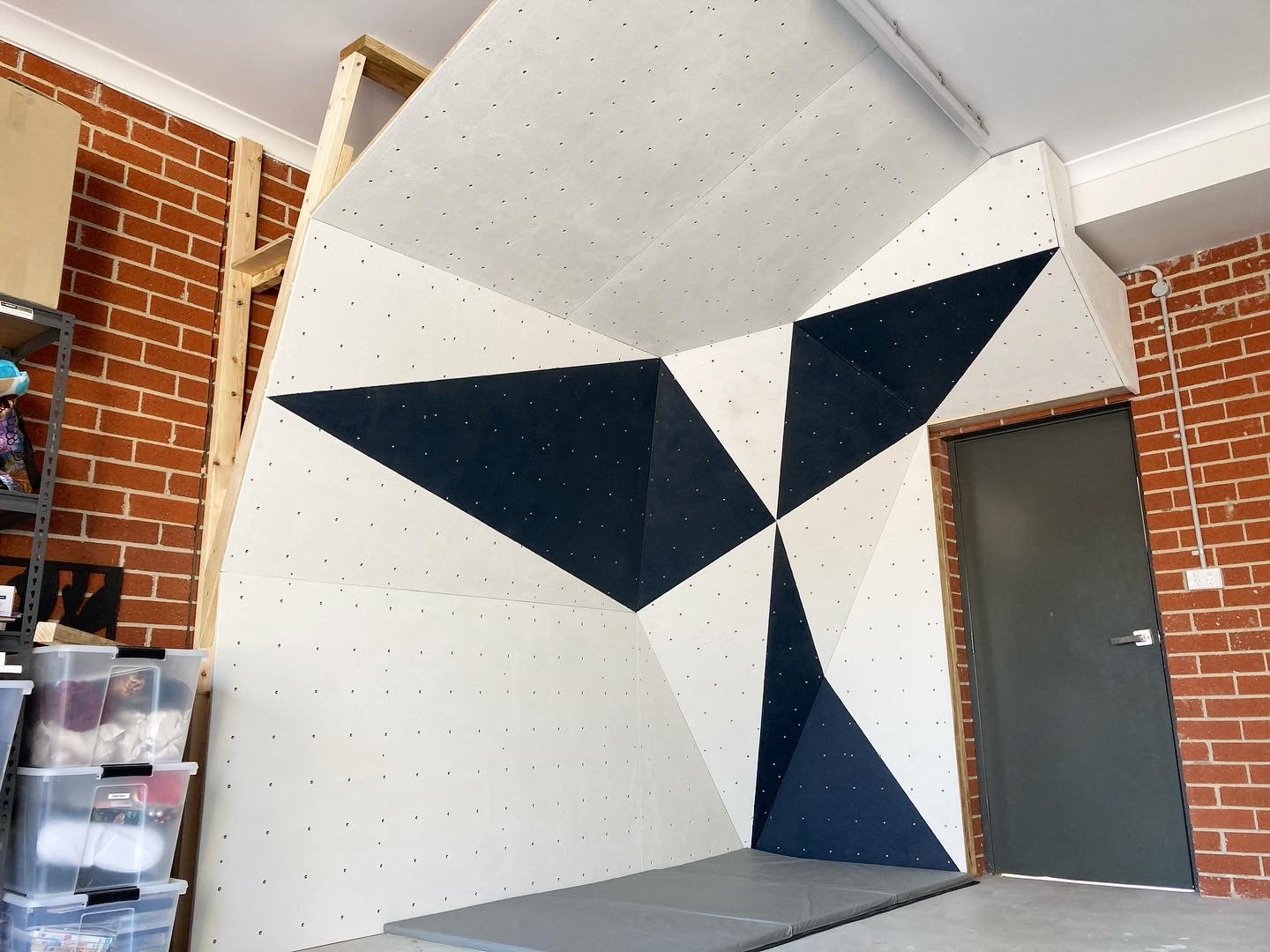 Custom home climbing wall with a geometric design, built by Project Climbing