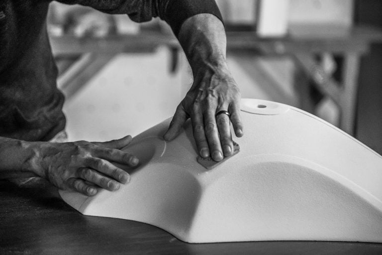 A hold shaper refining a new climbing hold shape