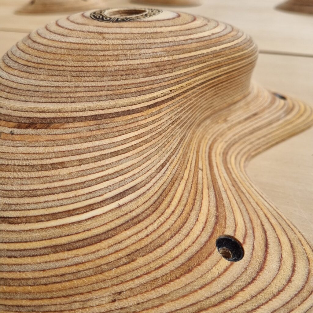 Druid Holds 2 Layers of birch plywood flowing across a Druid Holds wooden climbing hold