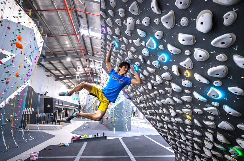 Climber on a Kilter Board in a climbing gym